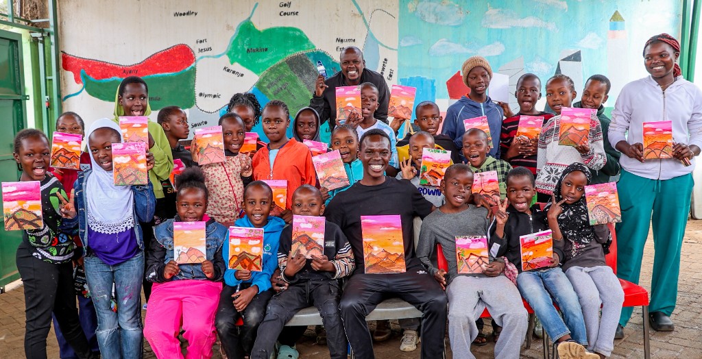 Children and Spur Afrika team holding artwork at a community gathering